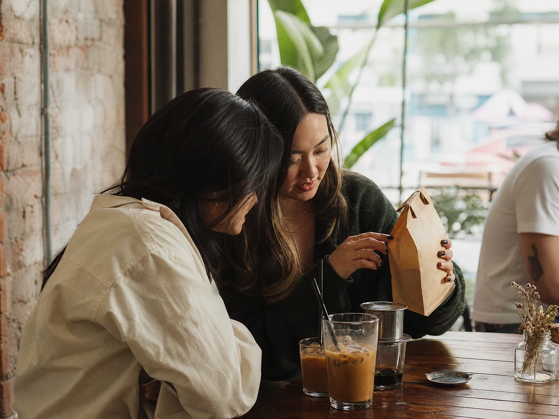 Friends choosing Vietnamese coffee beans at a Vancouver coffee shop